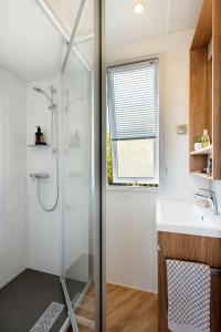 y baño con ducha y lavamanos. en PP-Camping Wallersee, en Seekirchen am Wallersee