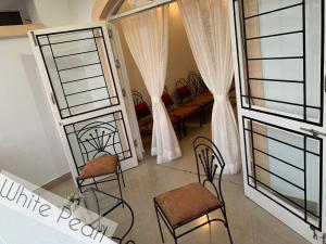 ein Wohnzimmer mit 2 Stühlen und einem Fenster in der Unterkunft Vistara By The Beach Goa in Marmagao