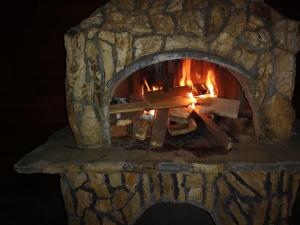 a stone oven with a fire in it at Konak -Guest house -Ramonda Serbika in Niš