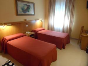 a hotel room with two beds and a window at Hotel Rey Arturo Burgos in Villagonzalo-Pedernales