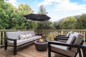 un patio con 2 sillas y una sombrilla en una terraza en Gaige House en Glen Ellen