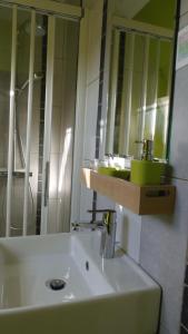 een badkamer met een witte wastafel en een spiegel bij Chambre Du Panorama in Barneville-sur-Seine