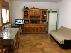 ein Wohnzimmer mit einem Tisch und einem Kühlschrank in der Unterkunft Casa Calanda in Calanda