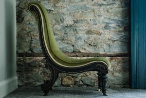 a green chair sitting in front of a stone wall at Suie Hunting Lodge in Killin +38 photos