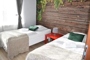 a room with two beds and a red table at Hostel Przed Świtem in Gorzów Wielkopolski