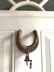 a horseshoe hanging on the door of a cabinet at Morse Cottage in Houston