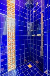 a blue tiled bathroom with a shower with blue tiles at Morse Cottage in Houston