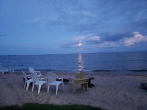 a group of chairs and a table on the beach at Paradise Beach resort in Tawas City