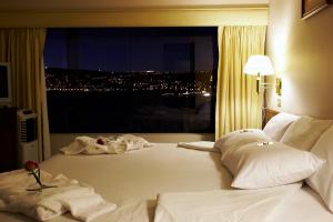 een hotelkamer met een groot bed en een raam bij GHL Hotel Lago Titicaca in Puno