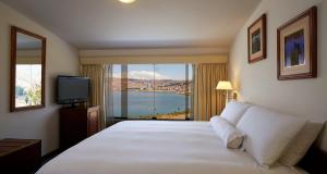 a bedroom with a large bed and a large window at GHL Hotel Lago Titicaca in Puno