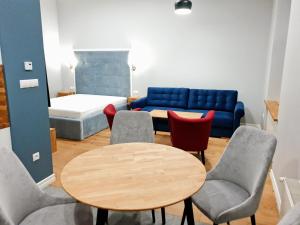 a room with a table and chairs and a couch at Apartamenty Centrum - Mickiewicza in Bielsko-Biała