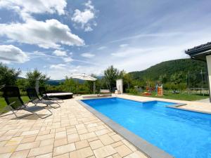 a swimming pool with chairs and a house at Villa Diamond in Bihać