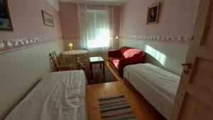 Cette petite chambre comprend deux lits et une chaise. dans l'établissement Majakovski Family Suite, à Sillamäe
