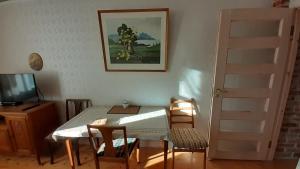 comedor con mesa, sillas y TV en Majakovski Family Suite en Sillamäe