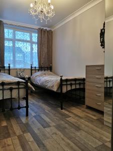 Un dormitorio con dos camas y una lámpara de araña. en Palaz 2 - 2 Bedroom Flat, en Edmonton