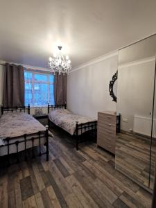 Un dormitorio con dos camas y una lámpara de araña. en Palaz 2 - 2 Bedroom Flat, en Edmonton