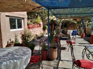 un patio con mesa, sillas y macetas en Kasbah de Ouirgane en Ouirgane