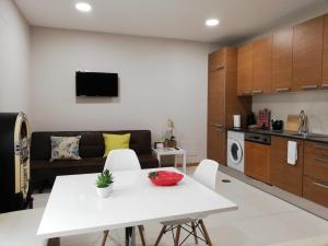 cocina y sala de estar con mesa blanca y sillas en Lovely Apartment @ Aveiro's Downtown, en Aveiro