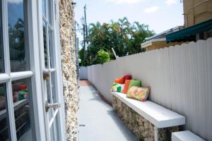 un banc avec des oreillers colorés assis à côté d'une clôture dans l'établissement Relax and Unwind in Little Havana - 2K, à Miami