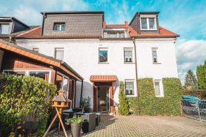 a white house with a red roof at Auberge Leipzig in Leipzig