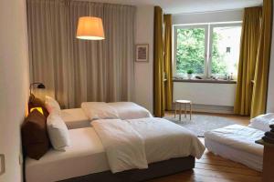 um quarto de hotel com duas camas e uma janela em Charmant Leben im Textilviertel - stilvolle Wohnung - zentral und ruhig em Augsburg