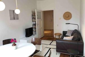 ein Wohnzimmer mit einem Sofa und einem Tisch in der Unterkunft Charmant Leben im Textilviertel - stilvolle Wohnung - zentral und ruhig in Augsburg