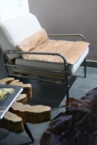 ein Bett mit einem Metallrahmen und einem hölzernen Fußhocker in der Unterkunft Casa com Quarto Simples a 4 KM do aeroporto de São José dos Pinhais in São José dos Pinhais