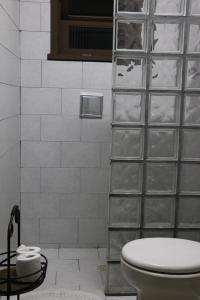 a bathroom with a toilet and a glass wall at Casa com Quarto Simples a 4 KM do aeroporto de São José dos Pinhais in São José dos Pinhais