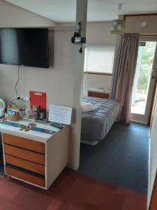 a hotel room with a bed and a desk in a room at Gateway To The Far North in Kaitaia