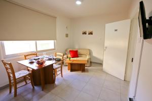 sala de estar con mesa, sillas y sofá en P. Ioannou Flats, en Lárnaca