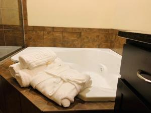 a bathroom with towels sitting on a bath tub at Roosevelt Inn & Suites in Watford City