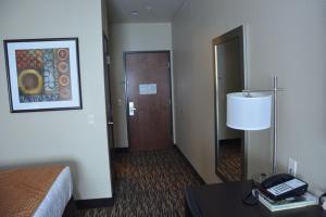 a hotel room with a bed and a table with a phone at Roosevelt Inn & Suites in Watford City