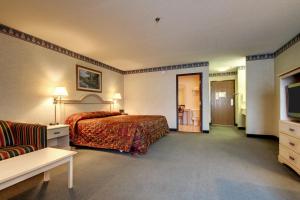 a hotel room with a bed and a television at Key West Inn - Baxley in Baxley