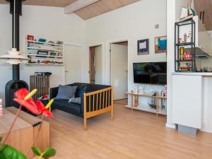 een woonkamer met een bank en een tv bij 8 person holiday home in Glesborg in Glesborg