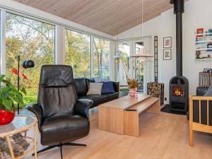 een woonkamer met een bank, een stoel en een open haard bij 8 person holiday home in Glesborg in Glesborg