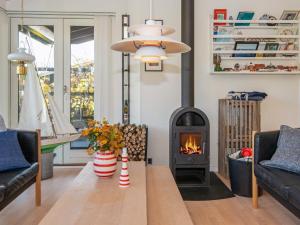 een woonkamer met een open haard en een tafel bij 8 person holiday home in Glesborg in Glesborg