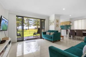 a living room with a couch and a dining room at Golden Shores Unit 1 21 Landsborough Parade in Caloundra