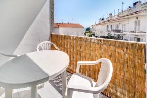 d'une table et de chaises blanches sur un balcon avec vue. dans l'établissement Hauzify I Apartaments Sot del Morer, à San Pol de Mar