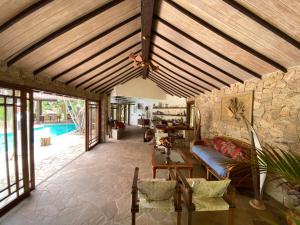 a living room with a wooden ceiling and a pool at Anfiteatro Tropical in Búzios