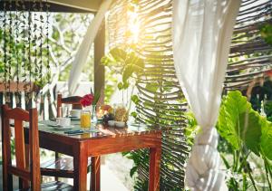 una mesa en un porche con plantas en Samba do Kite Pousada, en Jericoacoara