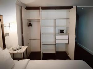 1 dormitorio con 1 cama, mesa pequeña y microondas en SUITES LONDRES 212, en Ciudad de México