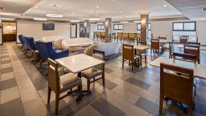 un restaurante con mesas y sillas y una sala de espera en Best Western Inn & Suites - Midway Airport en Burbank