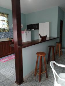 a kitchen with a counter and stools in a room at APARTAMENTO SIMPLES E ACONCHEGANTE in Paraty +9 photos