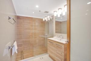 a bathroom with a shower, sink, and mirror at Aegean Resort Apartments in Gold Coast