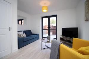 een woonkamer met een blauwe bank en een tv bij No1 Marina Walk by Stay South Wales -FREE Parking in Swansea