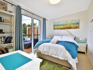 a bedroom with a bed and a large window at Arklow I Pet Friendly with Ocean Views in Culburra Beach
