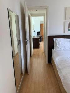 a bedroom with a bed and a hallway with a mirror at Condomínio Premium Suítes 02 in Rio de Janeiro