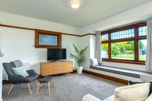 uma sala de estar com uma televisão, um sofá e uma janela em Stylish on Severne em Blenheim
