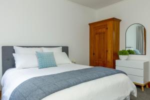 um quarto com uma cama, uma cómoda e um espelho em Stylish on Severne em Blenheim