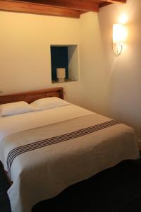 a bedroom with a large white bed in a room at Casa de Almagreira - Empreendimento de Turismo em Espaço Rural - Casa de Campo in Vila do Porto